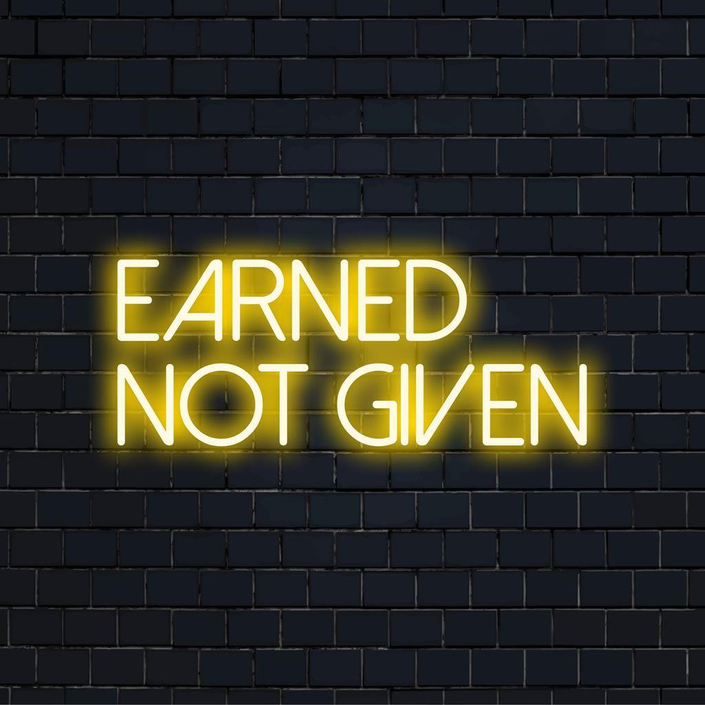 Individuelles LED-Neonschild der Marke The Art Neon mit dem inspirierenden Satz „Earned Not Given“ in lebendigen, leuchtenden Buchstaben.