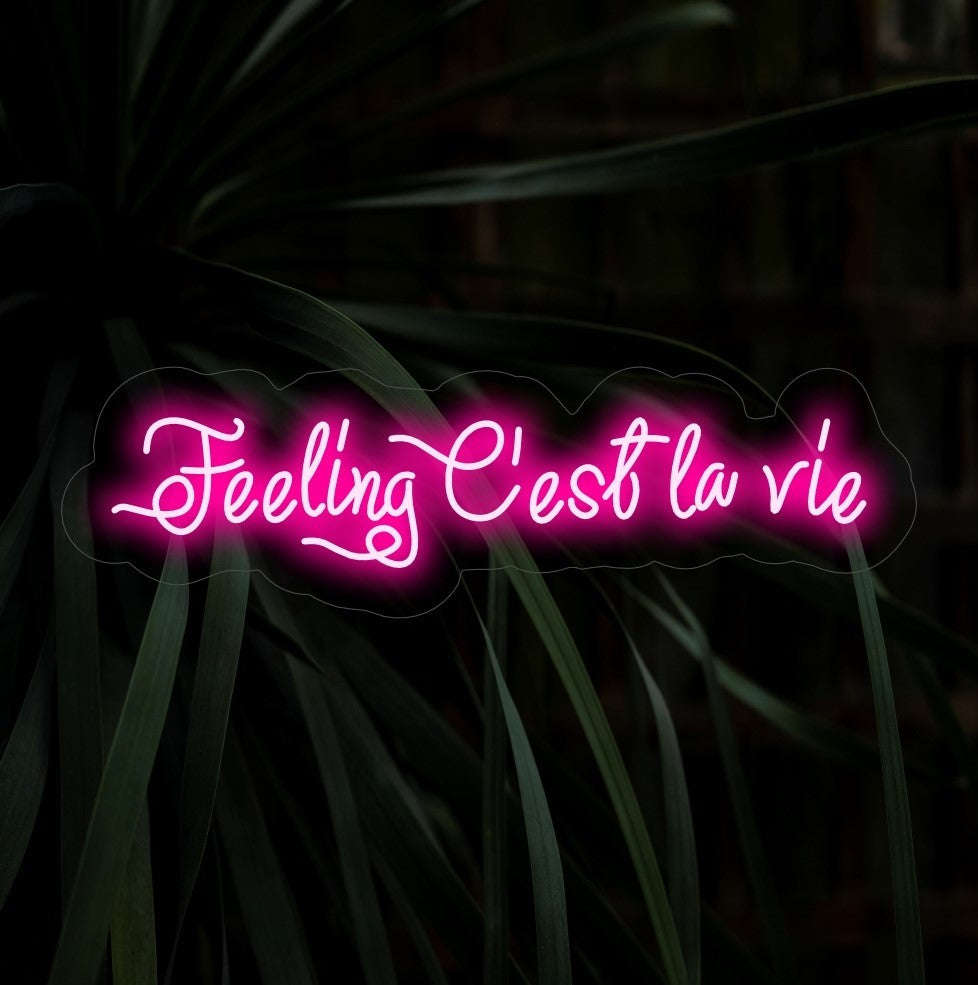 „Feeling C'est La Vie Neon Sign“ leuchtet in einem unbeschwerten Glanz, ideal für Räume, die die spielerische Einstellung eines Lebens in vollen Zügen mit einem Hauch von französischem Flair zum Ausdruck bringen.