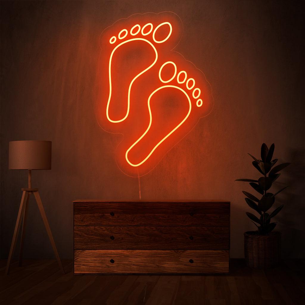 „Footprints Neon Sign“ – Hinterlässt einen Eindruck der Einzigartigkeit, perfekt für abenteuerliche Themenbereiche und Outdoor-Läden, die die individuelle Reise feiern.