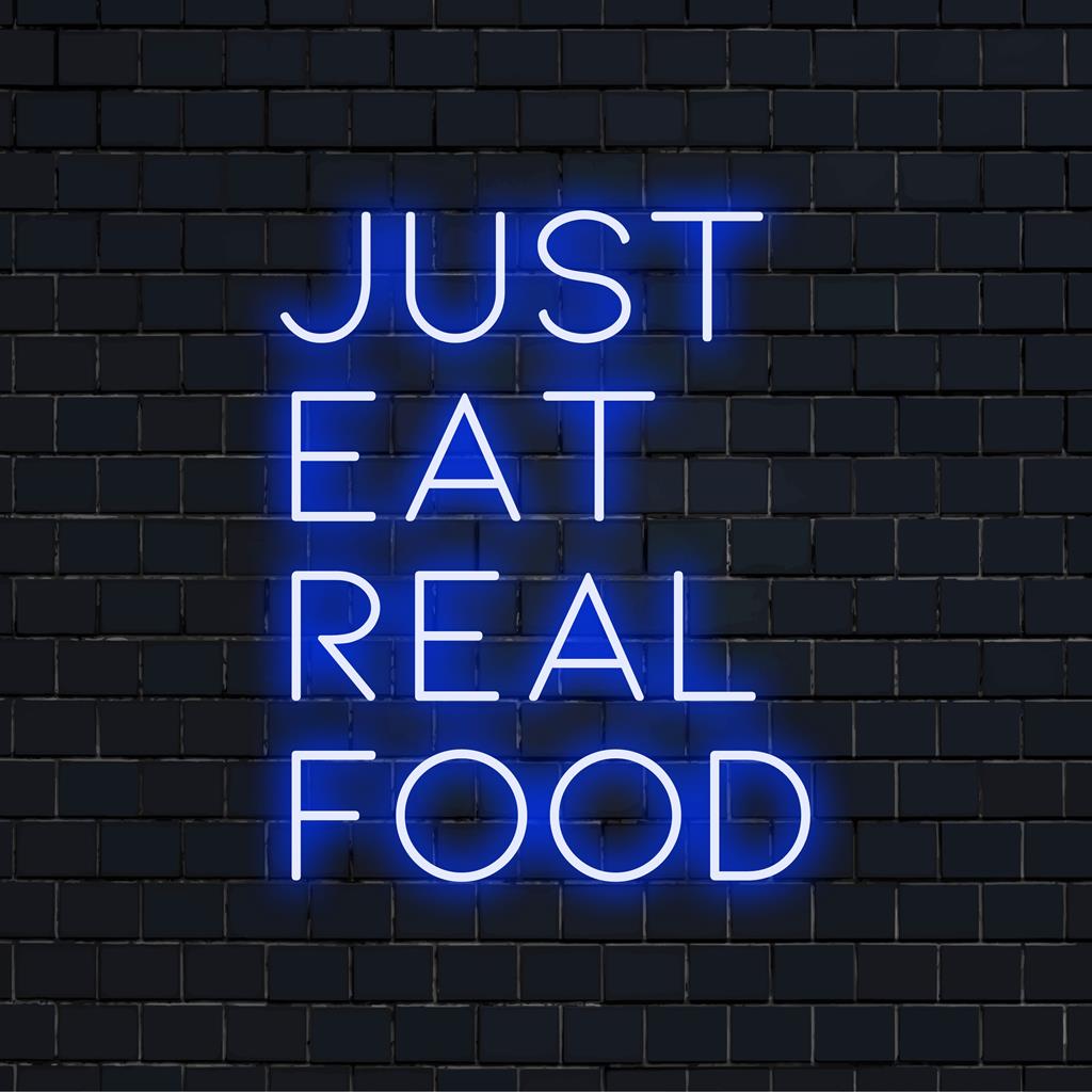 Leuchtendes Neonschild mit der Botschaft „Just Eat Real Food“ in leuchtenden LED-Lichtern; perfekt für moderne Einrichtung und Wellness-Enthusiasten.