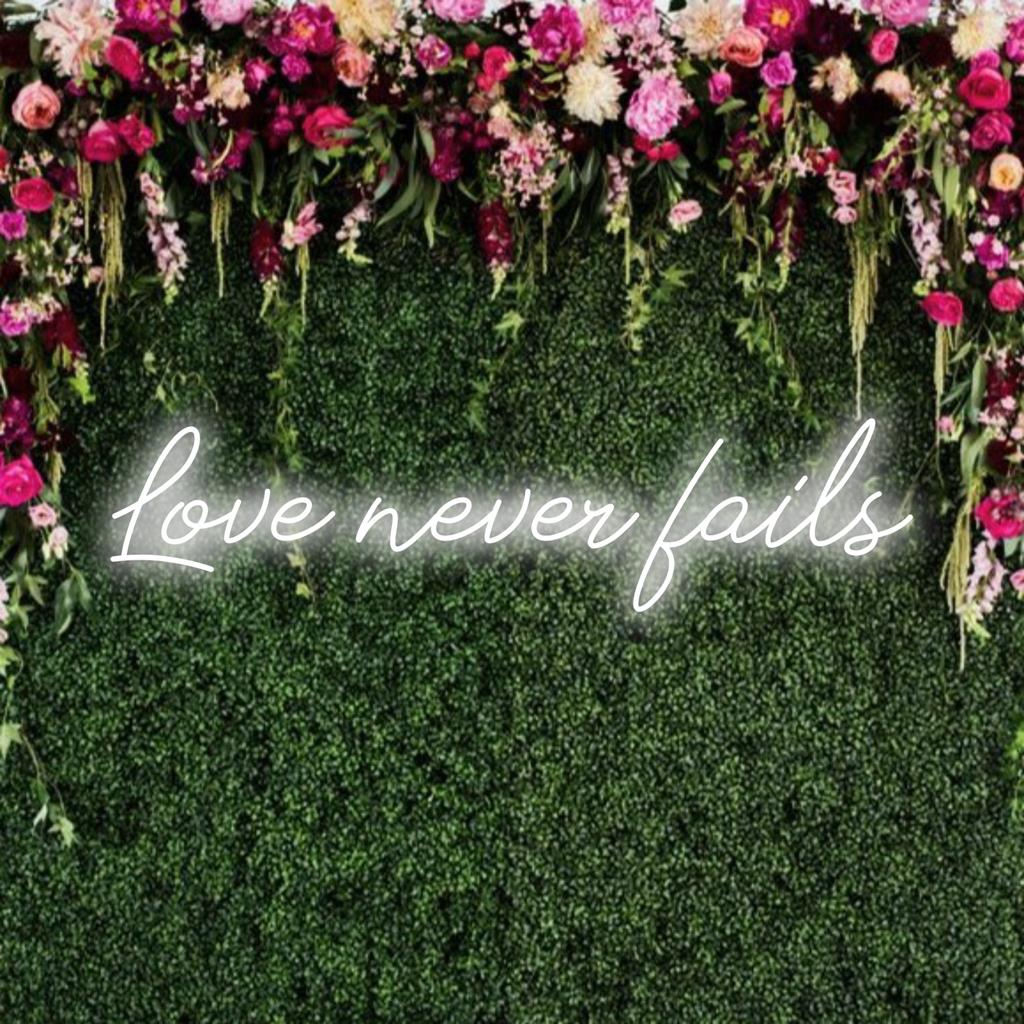LED-Neonschild mit der Aufschrift „Love Never Fails“ in strahlenden Farben; perfekt für die richtige Atmosphäre und zum Ausdruck ewiger Liebe.