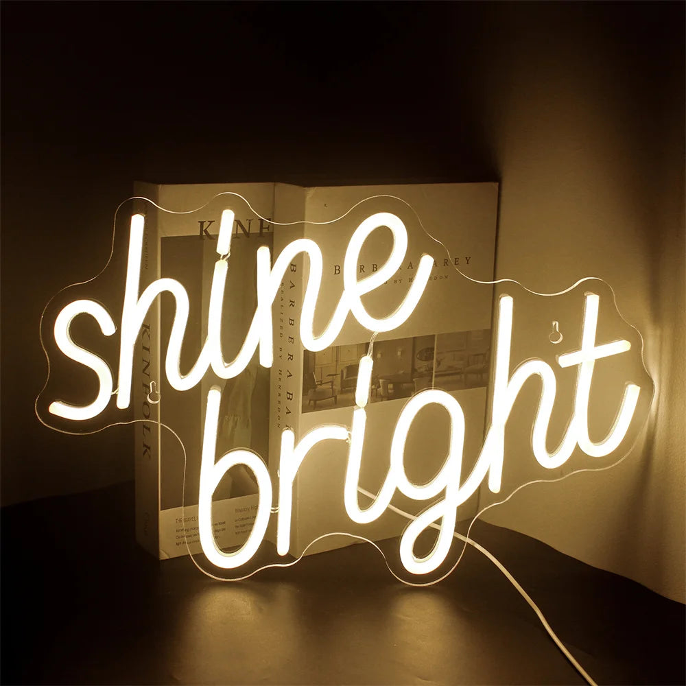 Ein leuchtendes LED-Neonschild mit den Worten „Shine Bright“ in einer lebendigen Schreibschrift.