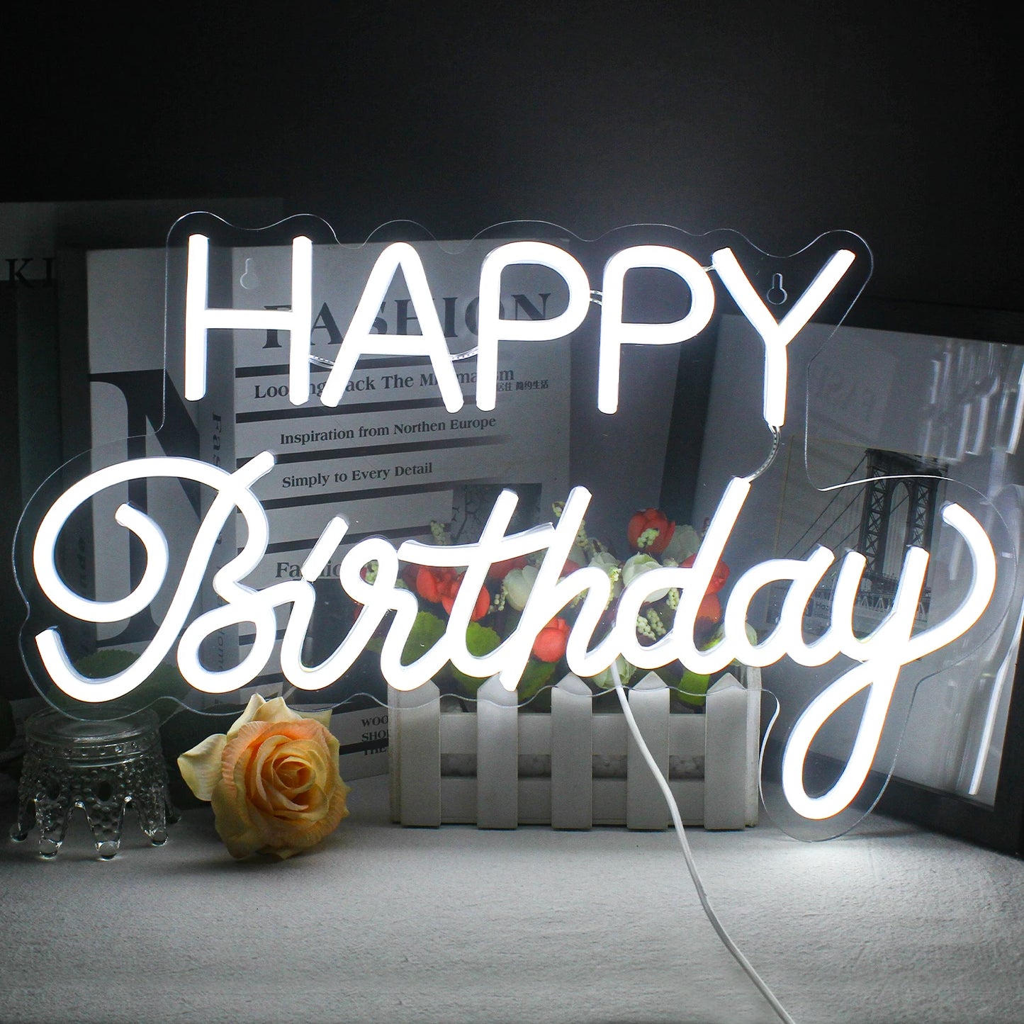 Das Bild zeigt ein leuchtendes LED-Neonschild, auf dem in eleganter Schreibschrift „Happy Birthday“ steht.