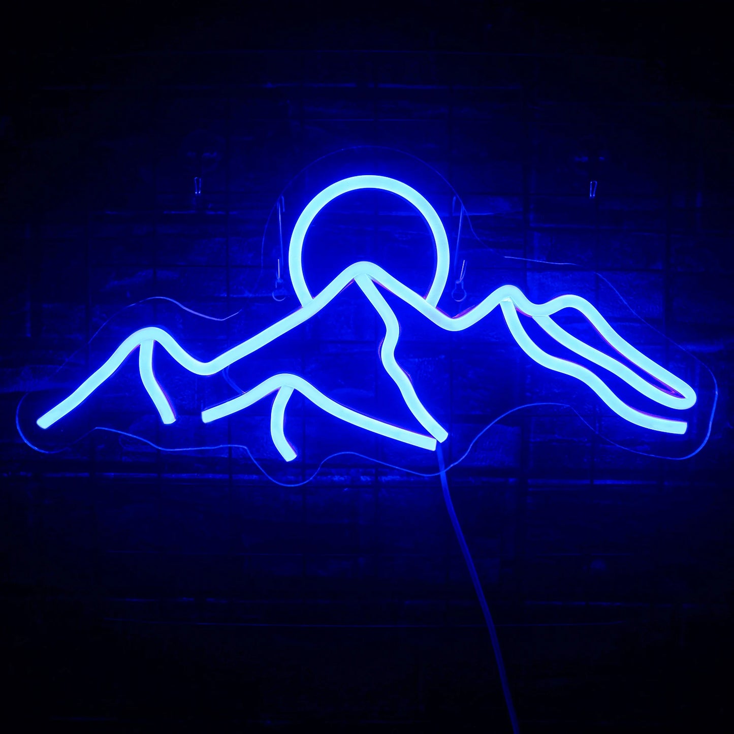 Das Bild zeigt ein leuchtendes LED-Neonschild mit der Darstellung einer Sonnenuntergangsszene in den Bergen.
