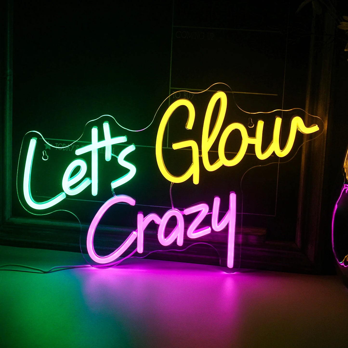 Das Bild zeigt ein leuchtendes, handgefertigtes LED-Neonschild mit der Aufschrift „Let’s Glow Crazy“.