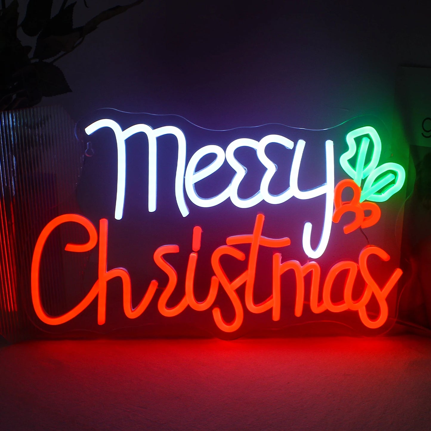 Das Bild zeigt ein leuchtendes, handgefertigtes LED-Neonschild mit den Worten „Frohe Weihnachten“ in eleganter Schreibschrift.