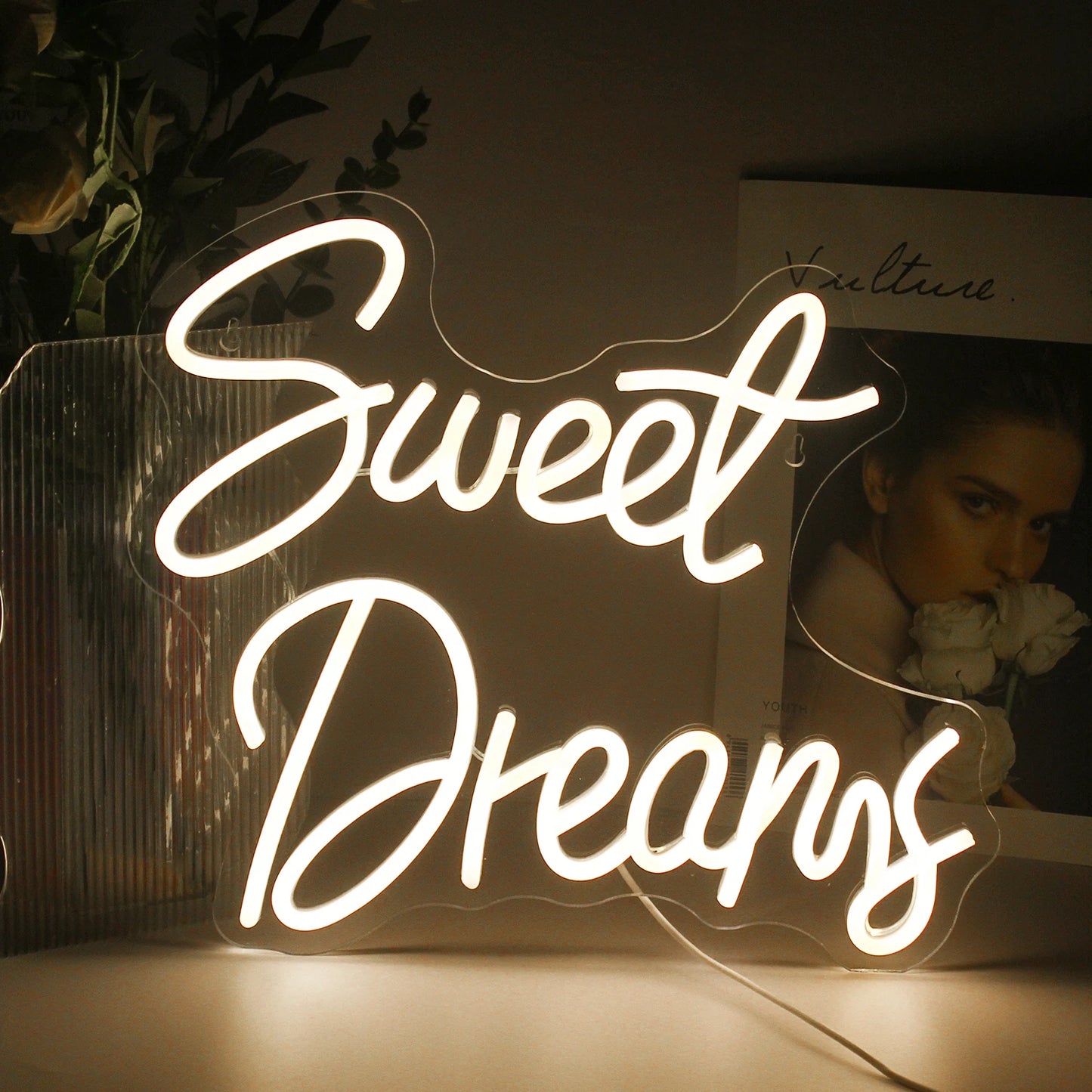 Das Bild zeigt ein stilvolles und lebendiges LED-Neonschild mit den Worten „Sweet Dreams“ in fließender, kursiver Schrift.