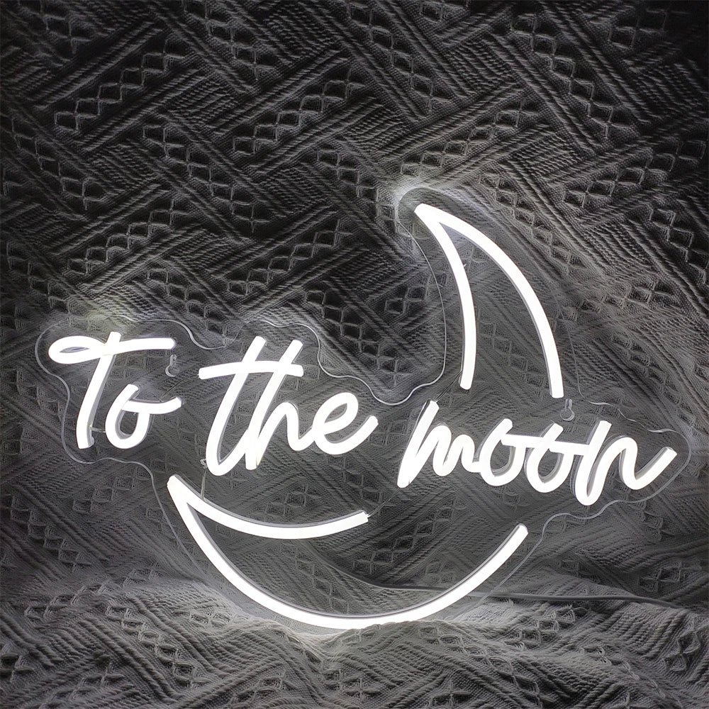 Ein leuchtendes LED-Neonschild mit dem Satz „To The Moon“ in einer eleganten, modernen Schriftart.