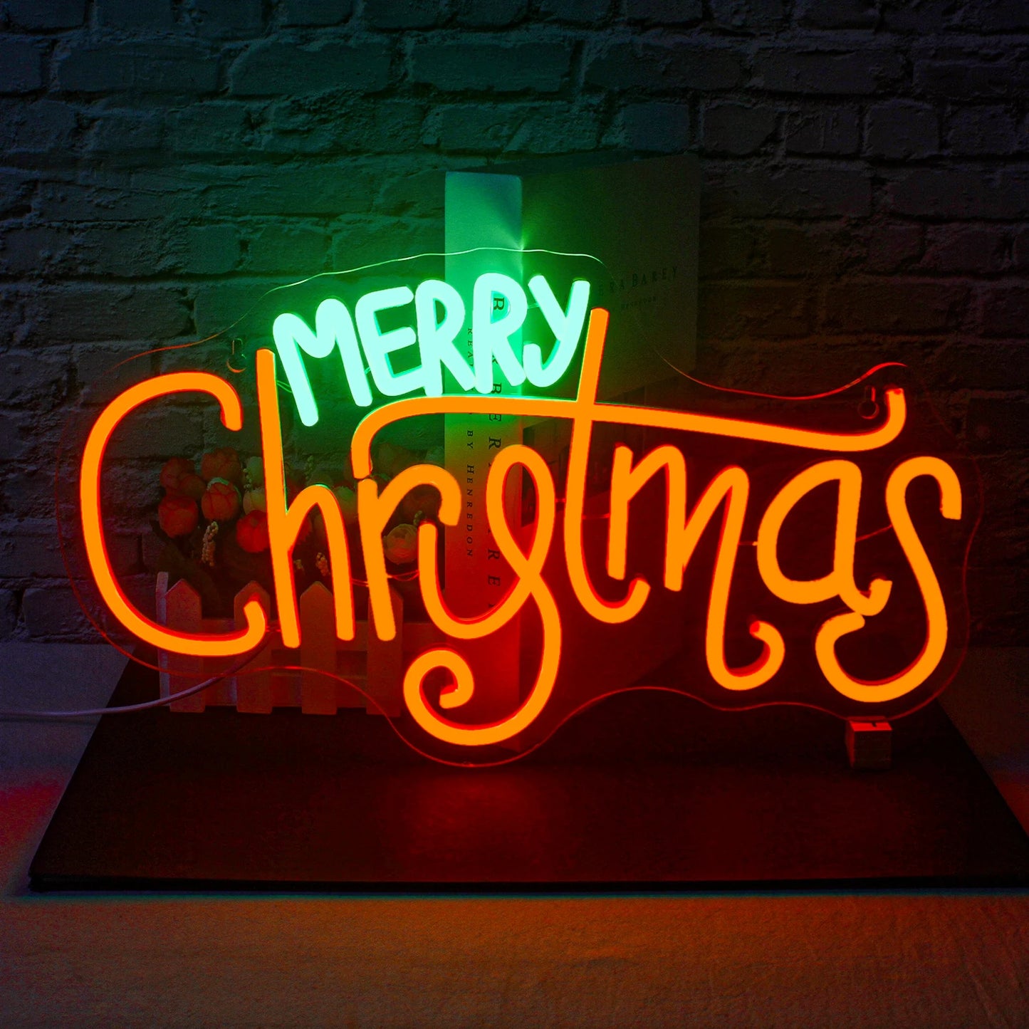 Ein leuchtendes LED-Neonschild mit der Aufschrift „Frohe Weihnachten“ mit fettem, kursivem Schriftzug in leuchtendem Rot.