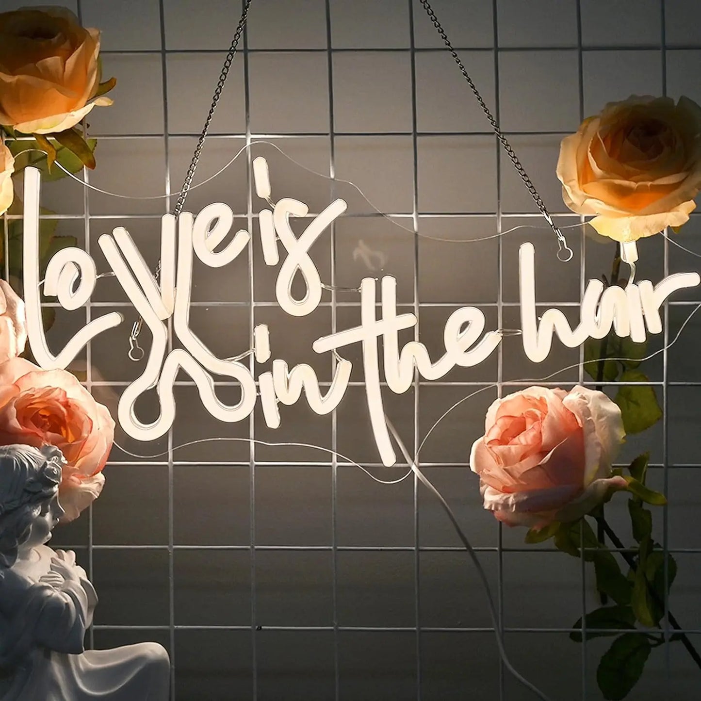 Das Bild zeigt ein leuchtendes, handgefertigtes LED-Neonschild mit der Aufschrift „Love is in the Hair“.