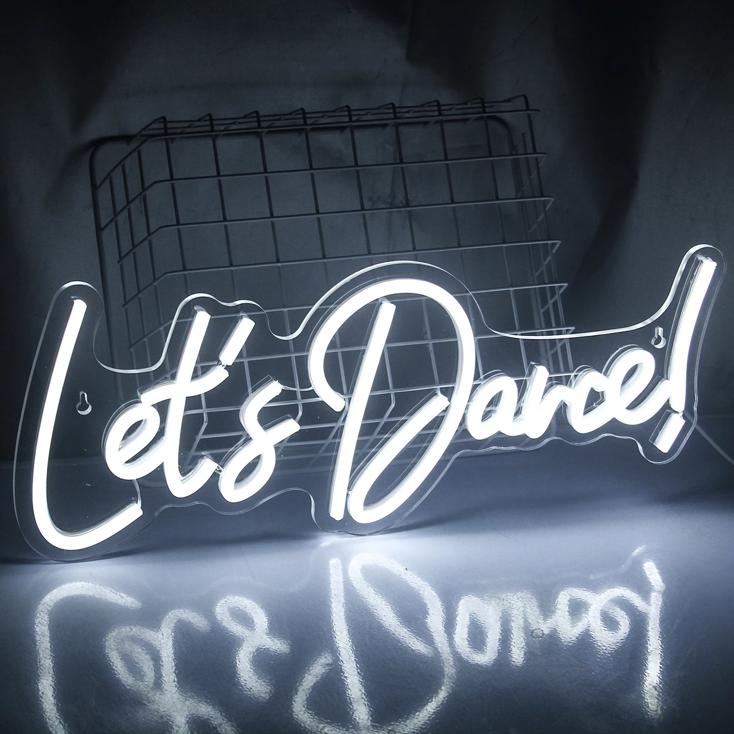 Ein hell erleuchtetes „Let’s Dance“-LED-Neonschild in leuchtenden Pink- und Blautönen.