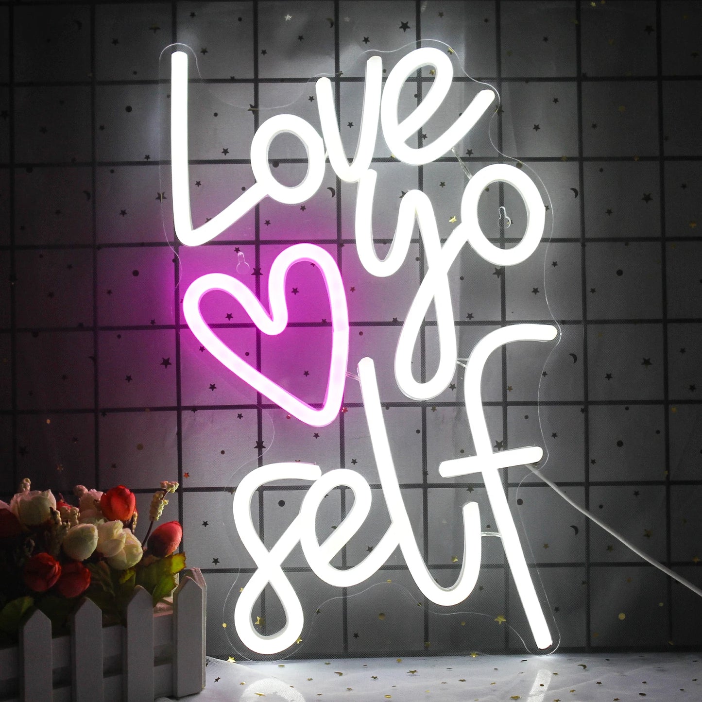 Das Bild zeigt ein leuchtendes LED-Neonschild mit den Worten „Love Yourself“, die in einer stilvollen Schreibschrift leuchten.