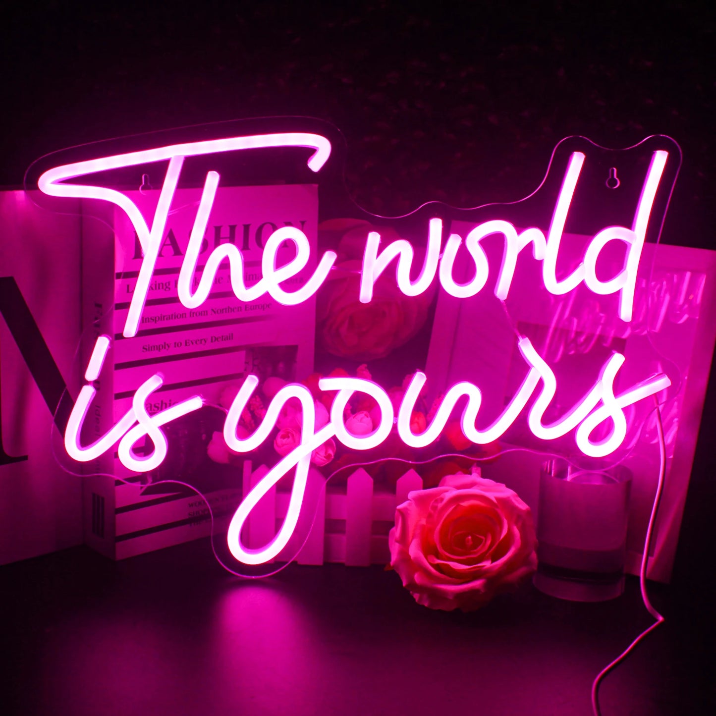 Ein leuchtendes LED-Neonschild mit dem Satz „Die Welt gehört dir“ in Schreibschrift.