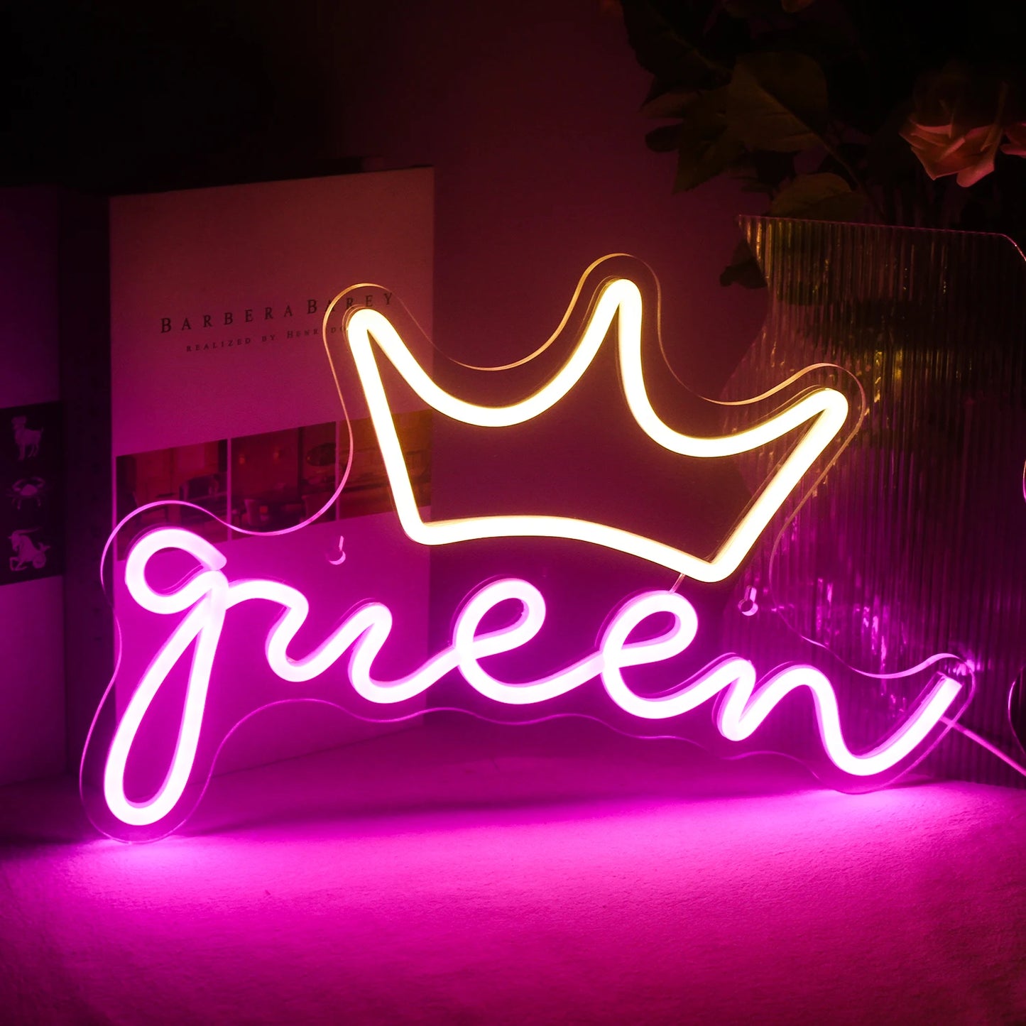 Es wird ein leuchtendes LED-Neonschild in Form des Wortes „Queen“ angezeigt.