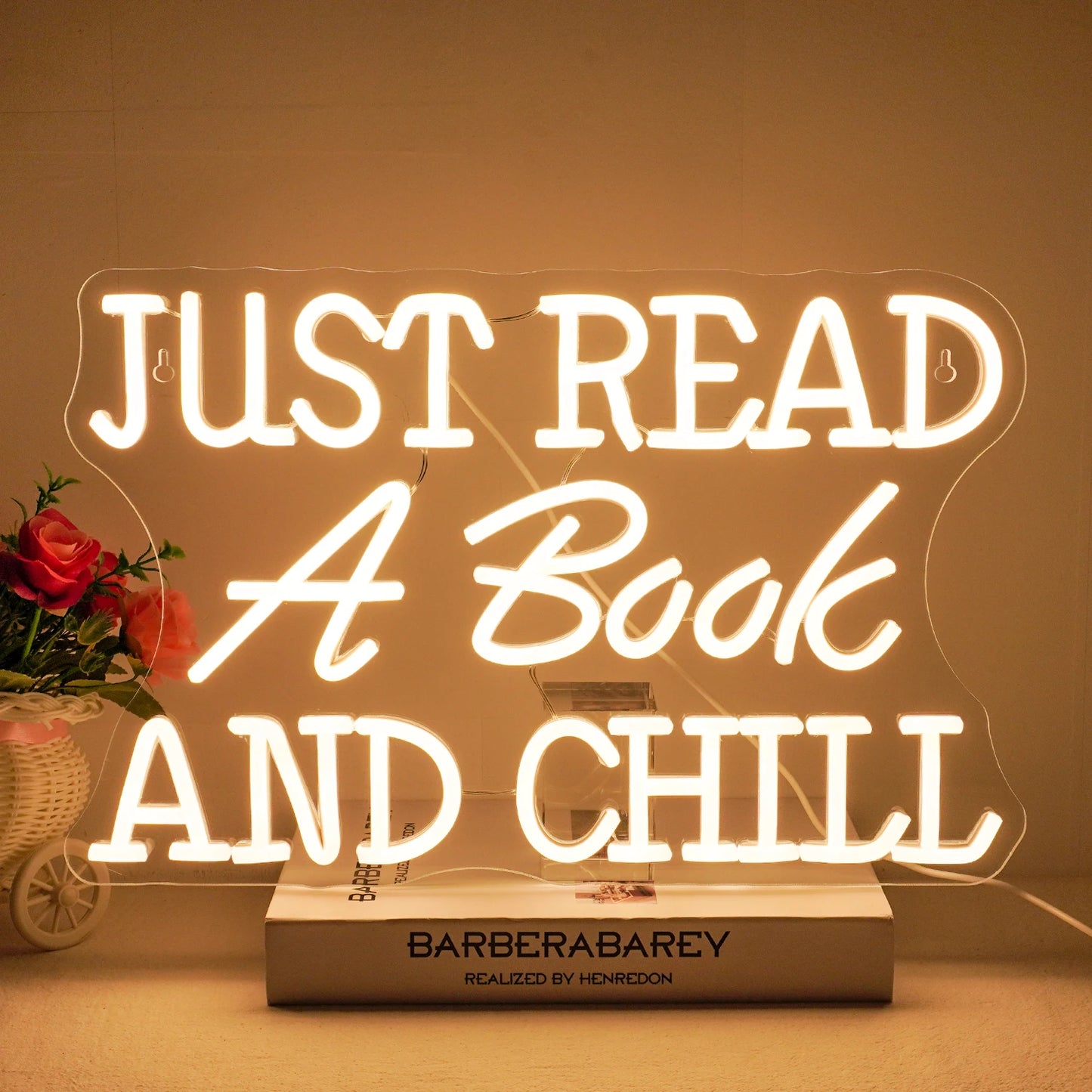 Das Bild zeigt ein leuchtendes LED-Neonschild mit der Aufschrift „Just Read A Book And Chill“.
