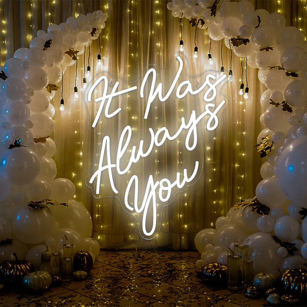 Ein leuchtendes LED-Neonschild mit dem Satz „It Was Always You“ in eleganter, fließender Schreibschrift.