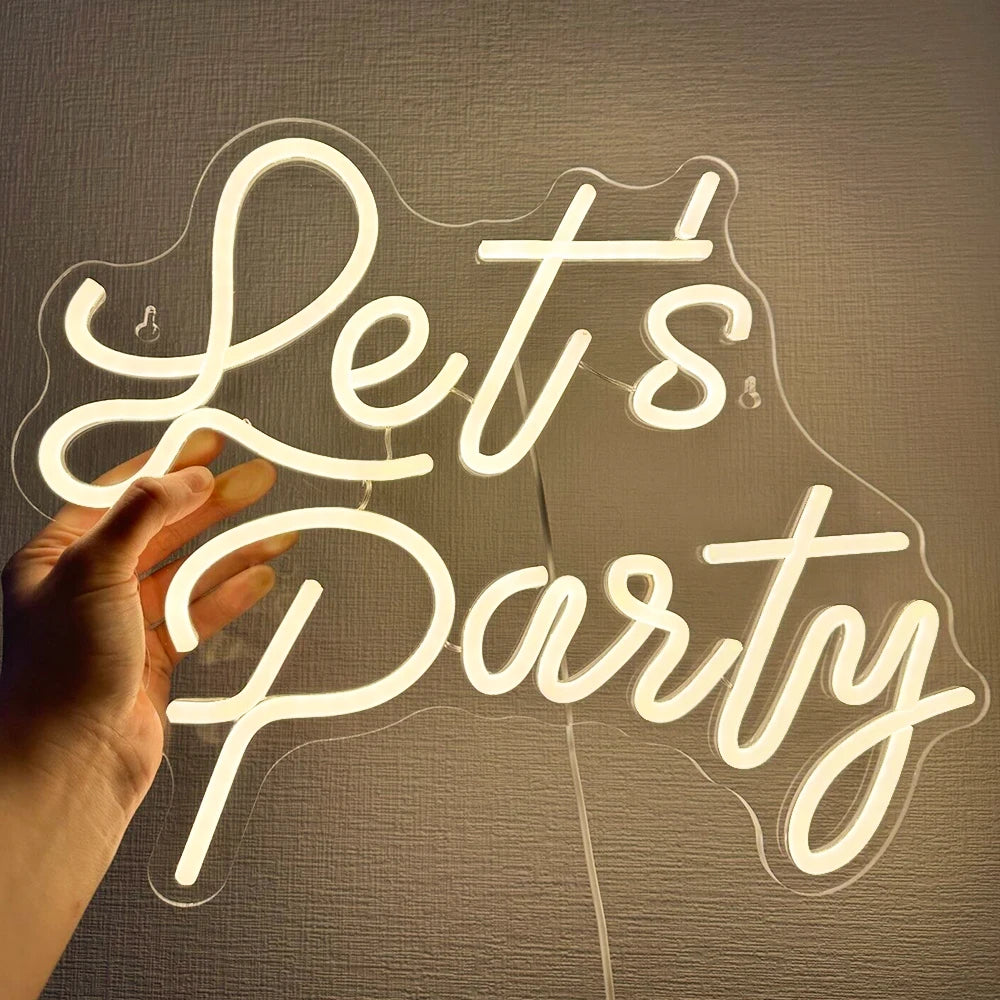 Ein leuchtendes LED-Neonschild mit den Worten „Let’s Party“ in fetter, kursiver Schrift.