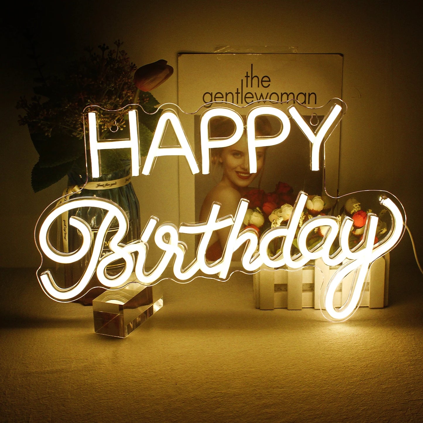 Ein leuchtendes LED-Neonschild mit den Worten „Happy Birthday“ in fließender Schreibschrift.