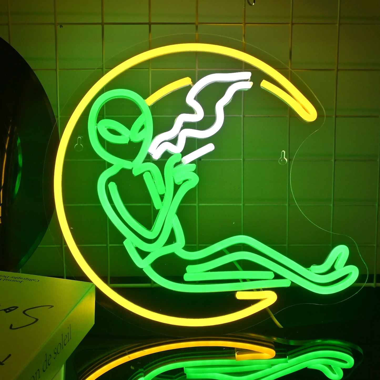 Ein leuchtendes LED-Neonschild mit der Darstellung einer skurrilen außerirdischen Figur.
