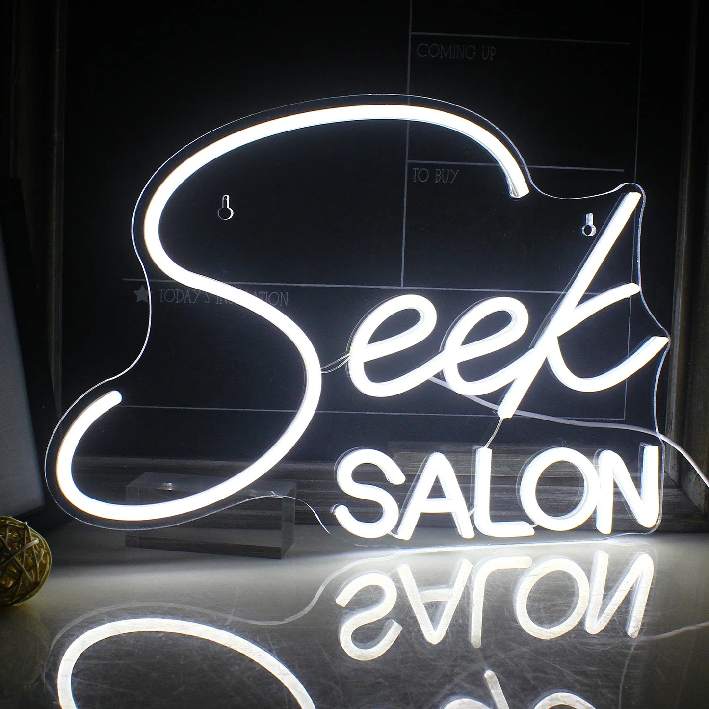 Das Bild zeigt ein leuchtendes LED-Neonschild mit dem Wort „SALON“ in stilisierten Großbuchstaben.