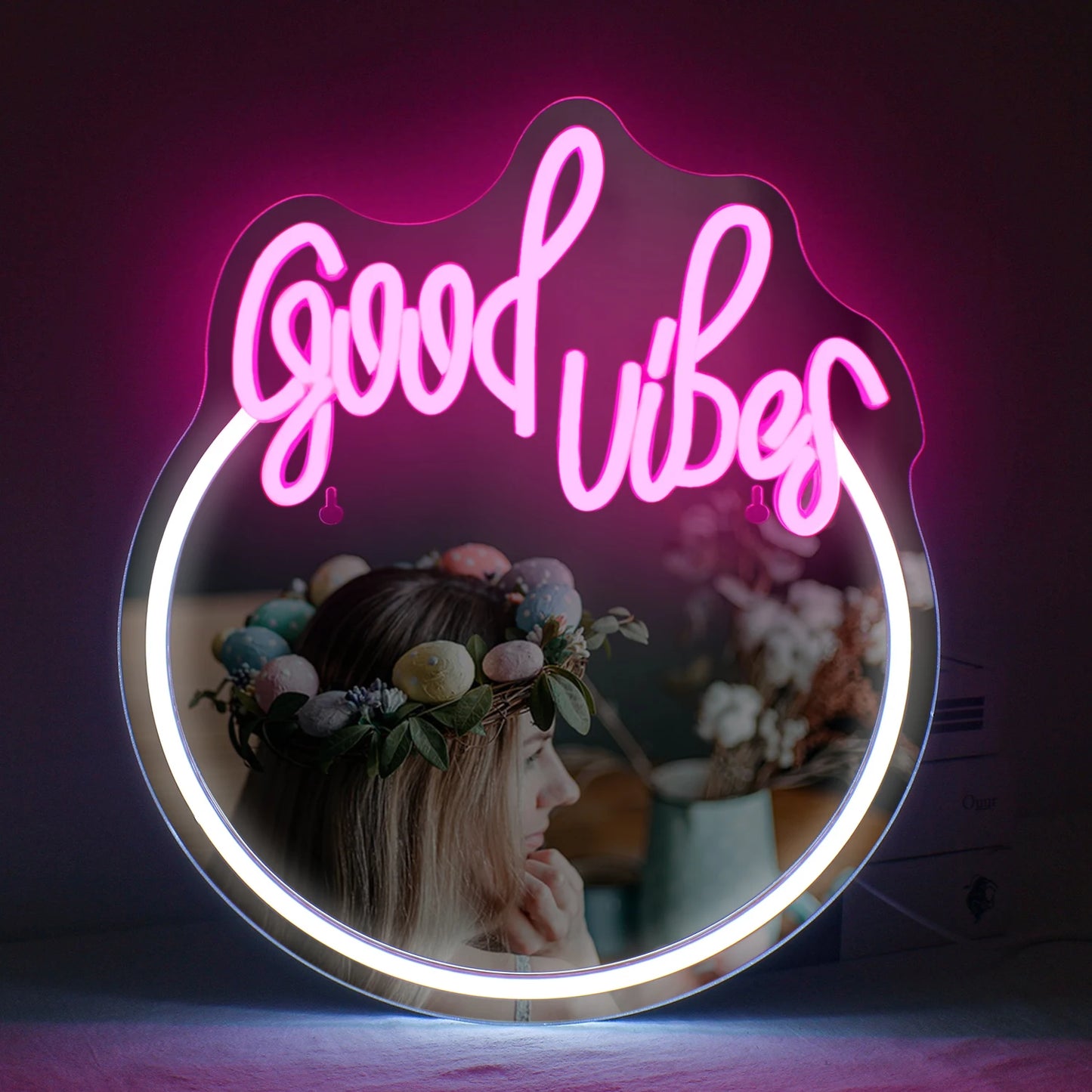 Das Bild zeigt ein stilvolles LED-Neonschild mit der Aufschrift „Good Vibes“ in leuchtend rosa Buchstaben.