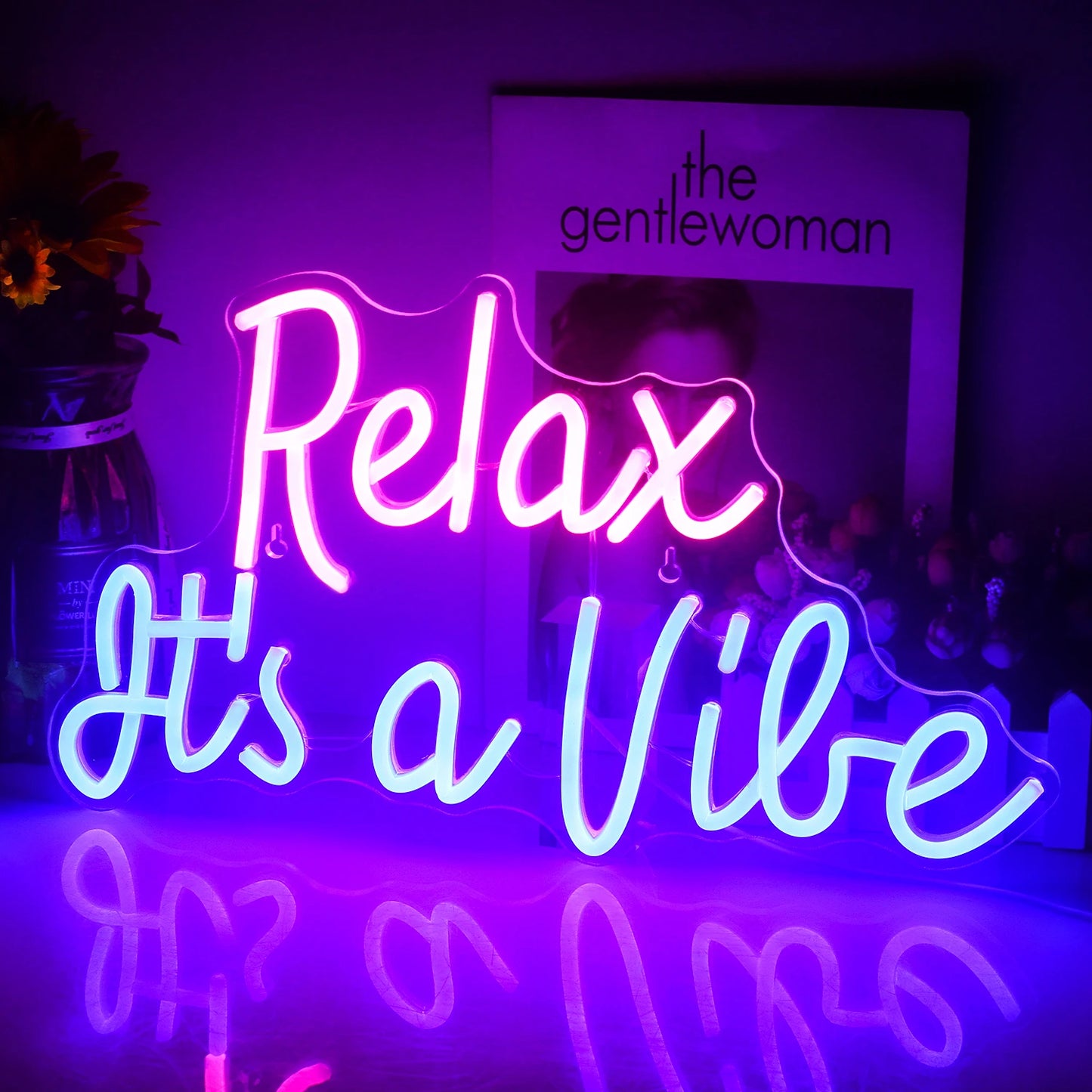 Das Bild zeigt ein leuchtendes LED-Neonschild mit dem Satz „Relax It’s a Vibe“ in einer stilvollen Schreibschrift.