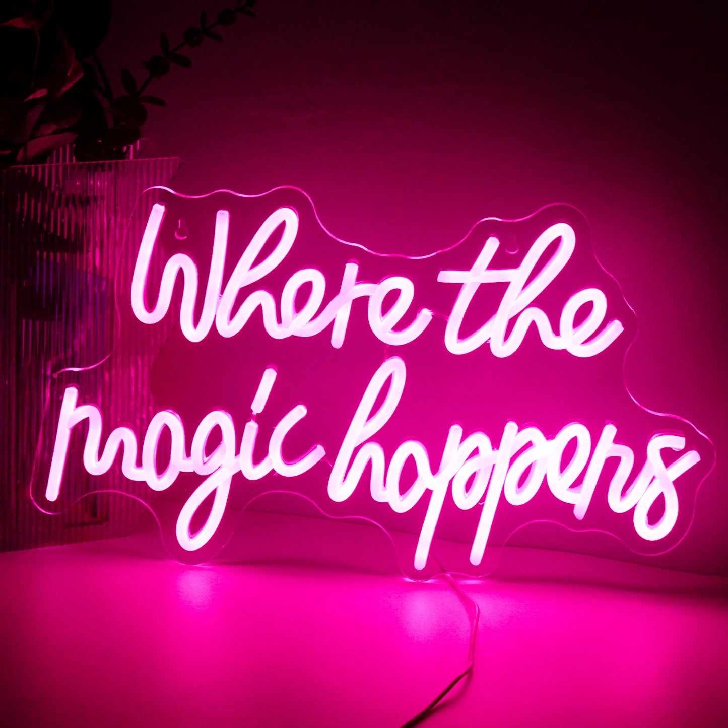 Das Bild zeigt ein leuchtendes LED-Neonschild mit der Aufschrift „Where The Magic Happens“ in einer eleganten, verspielten Schreibschrift.