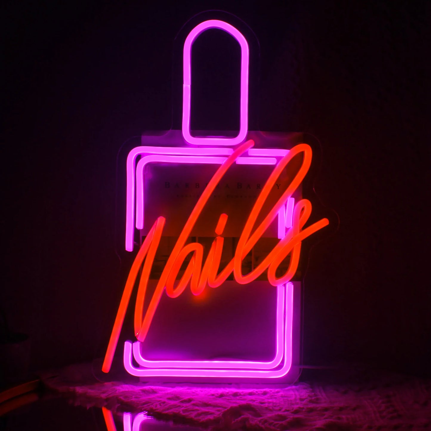 Das Bild zeigt ein leuchtendes LED-Neonschild, auf dem das Wort „Nails“ in einer stilvollen Schreibschrift steht.