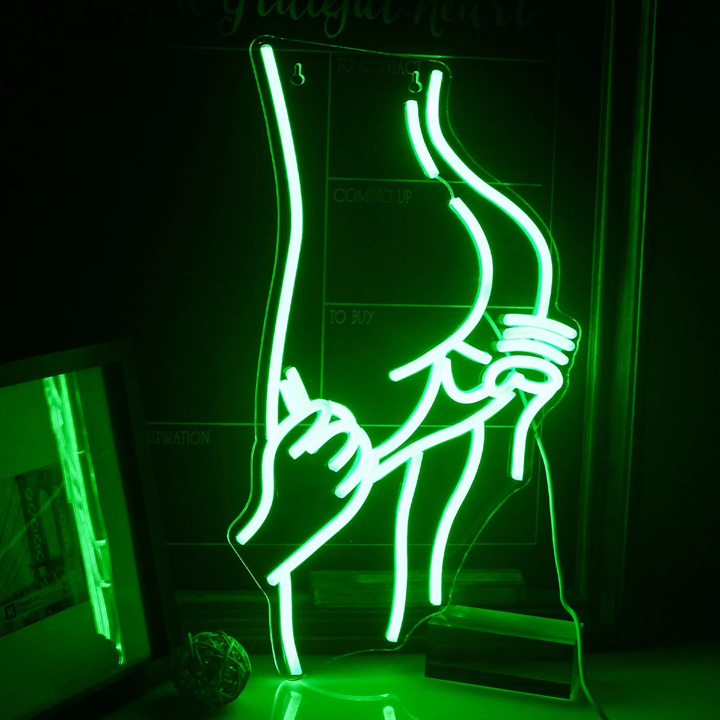 Das Bild zeigt ein leuchtendes LED-Neonschild in Form einer Silhouette, die die sinnliche, kurvenreiche Figur einer Frau darstellt.
