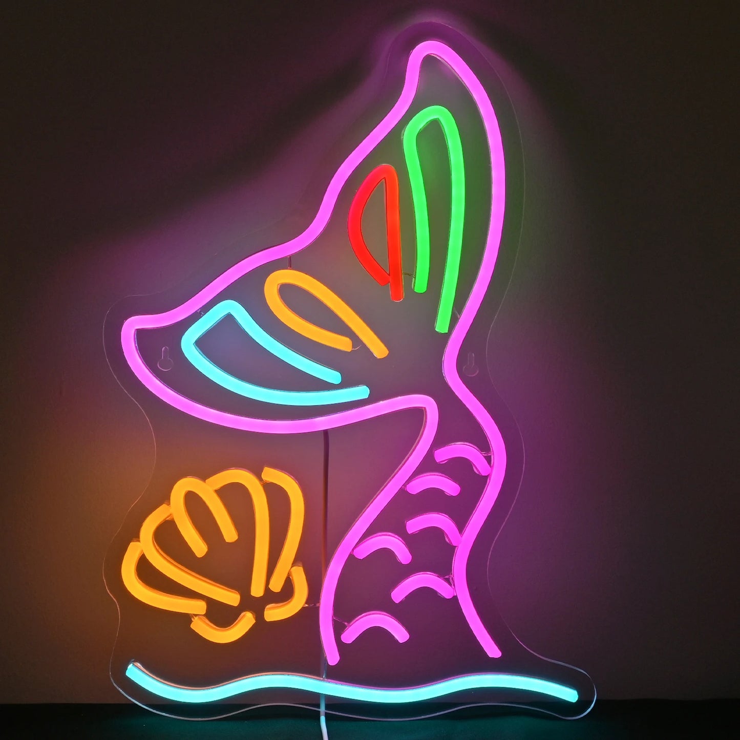 Das Bild zeigt ein leuchtendes LED-Neonschild in Form eines Meerjungfrauenschwanzes.