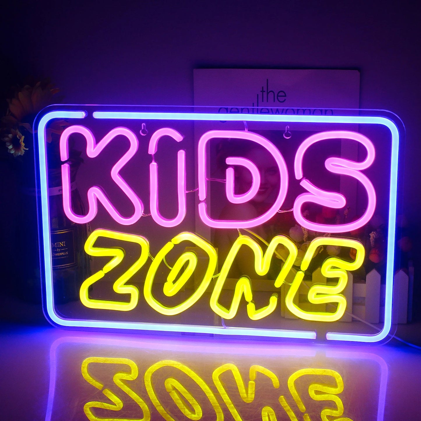 Das Bild zeigt ein leuchtendes LED-Neonschild mit den Worten „Kids Zone“ in einer verspielten, farbenfrohen Schriftart.