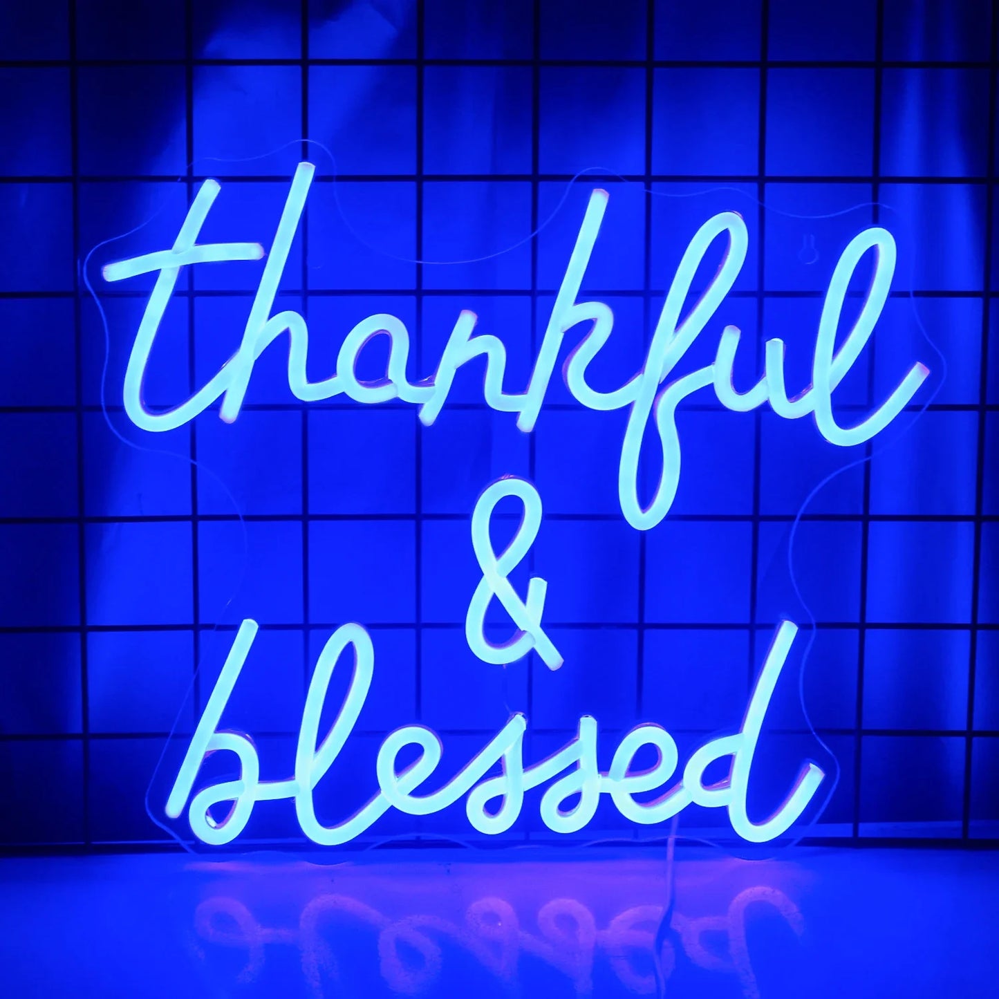Das Bild zeigt ein leuchtendes LED-Neonschild mit der Aufschrift „Thankful and Blessed“.