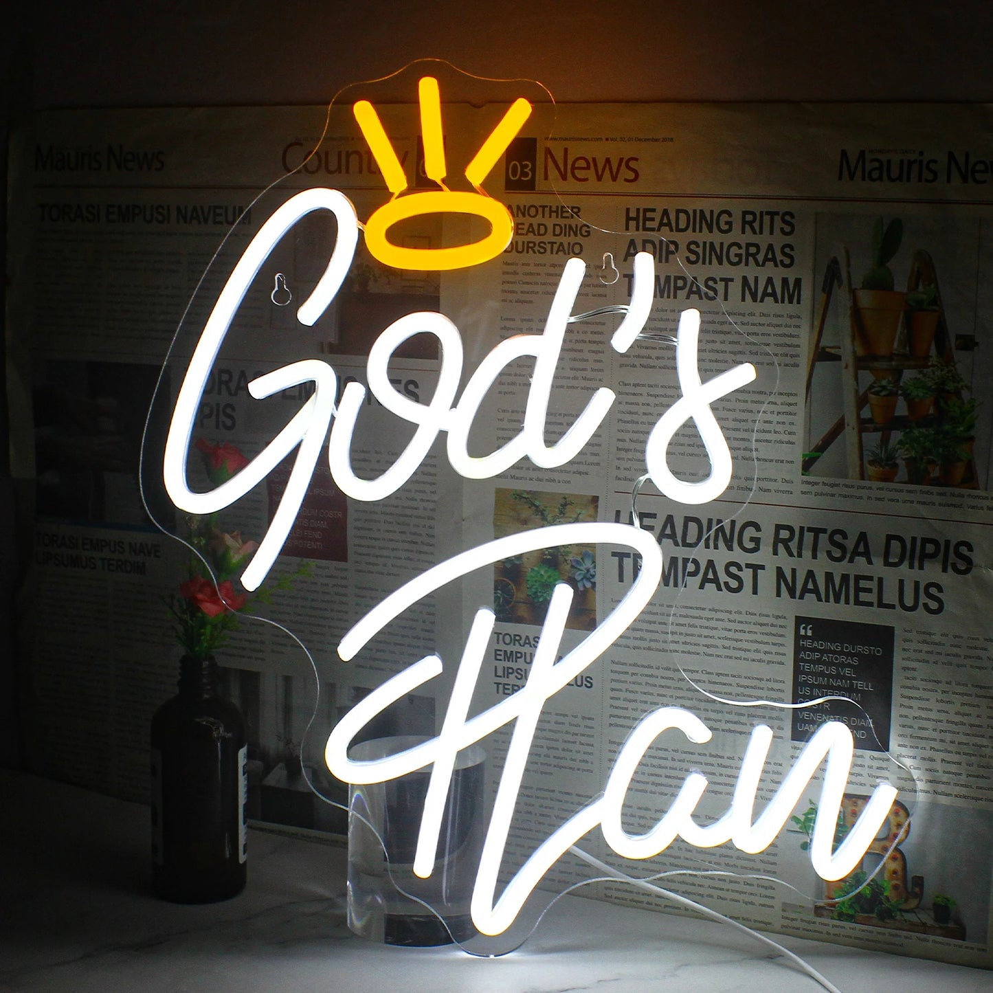 Ein leuchtendes LED-Neonschild mit dem Satz „Gottes Plan“ in eleganter Schreibschrift.