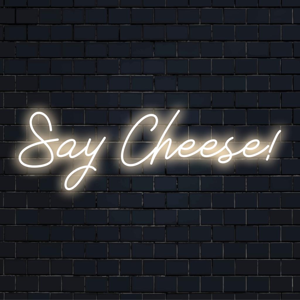 Leuchtendes Neonschild mit dem verspielten Spruch „Say Cheese!“; perfekt, um Ihrer Inneneinrichtung einen individuellen LED-Touch zu verleihen.