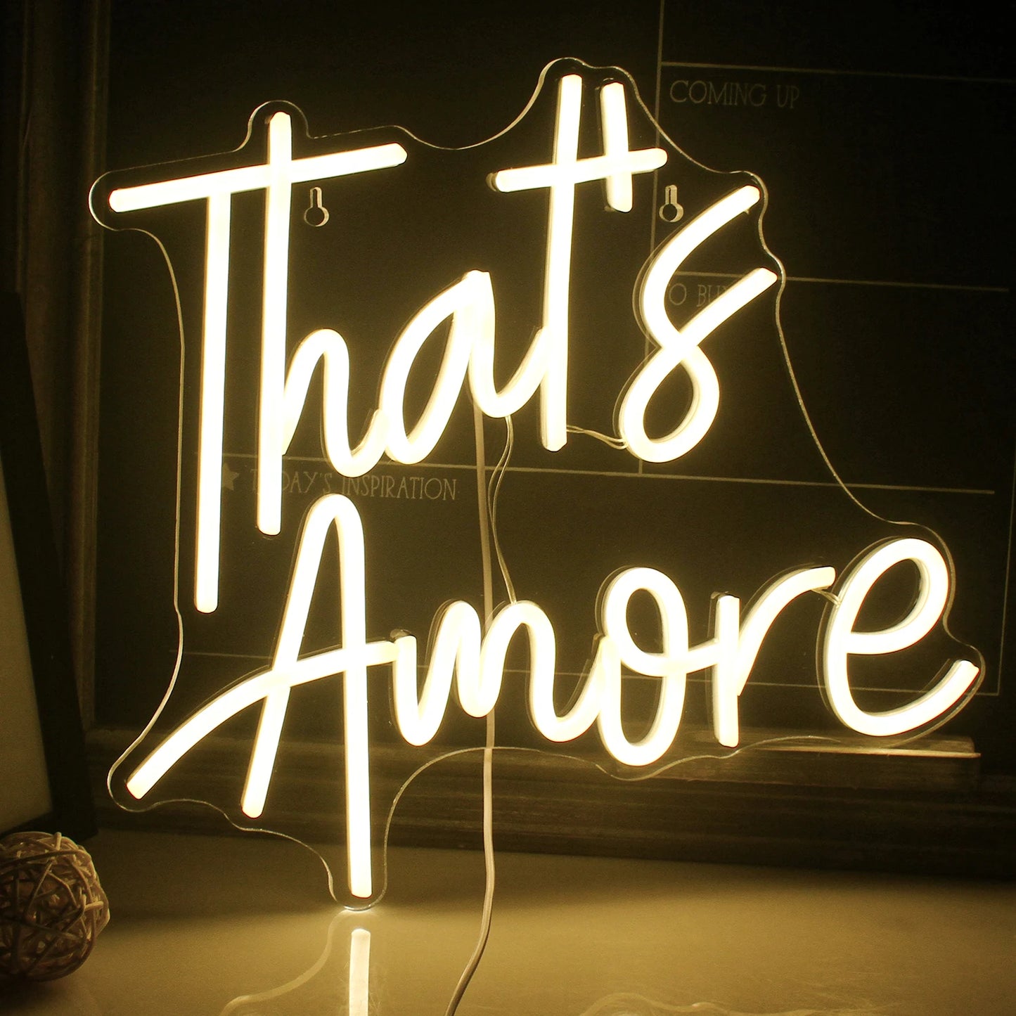 Ein lebendiges, handgefertigtes LED-Neonschild mit dem Wort „Amore“ in eleganter Schreibschrift.