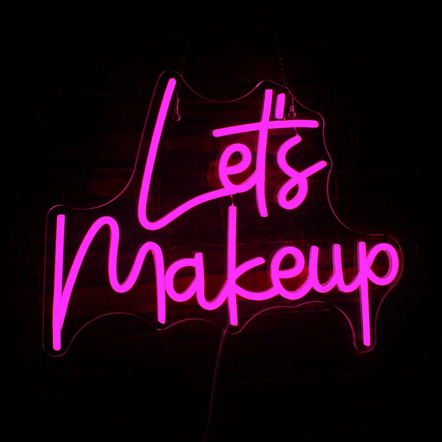Ein stilvolles LED-Neonschild mit dem Satz „Let’s Makeup“ in leuchtend rosa Schreibschrift.