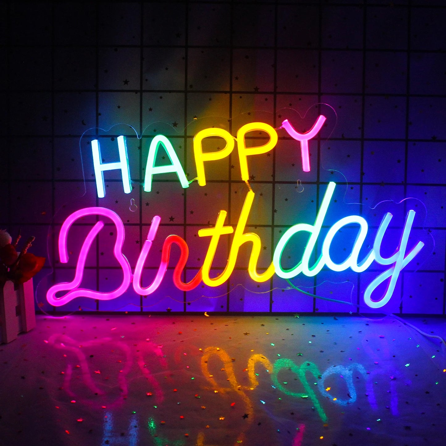 Ein leuchtendes „Happy Birthday“-LED-Neonschild in festlichen Farben, an einer Wand montiert.