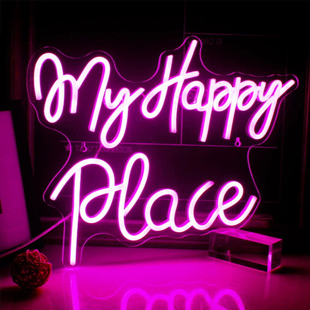 Ein leuchtendes LED-Neonschild mit der Aufschrift „My Happy Place“ ist gut sichtbar an einer Wand angebracht und verbreitet ein warmes und einladendes Licht.