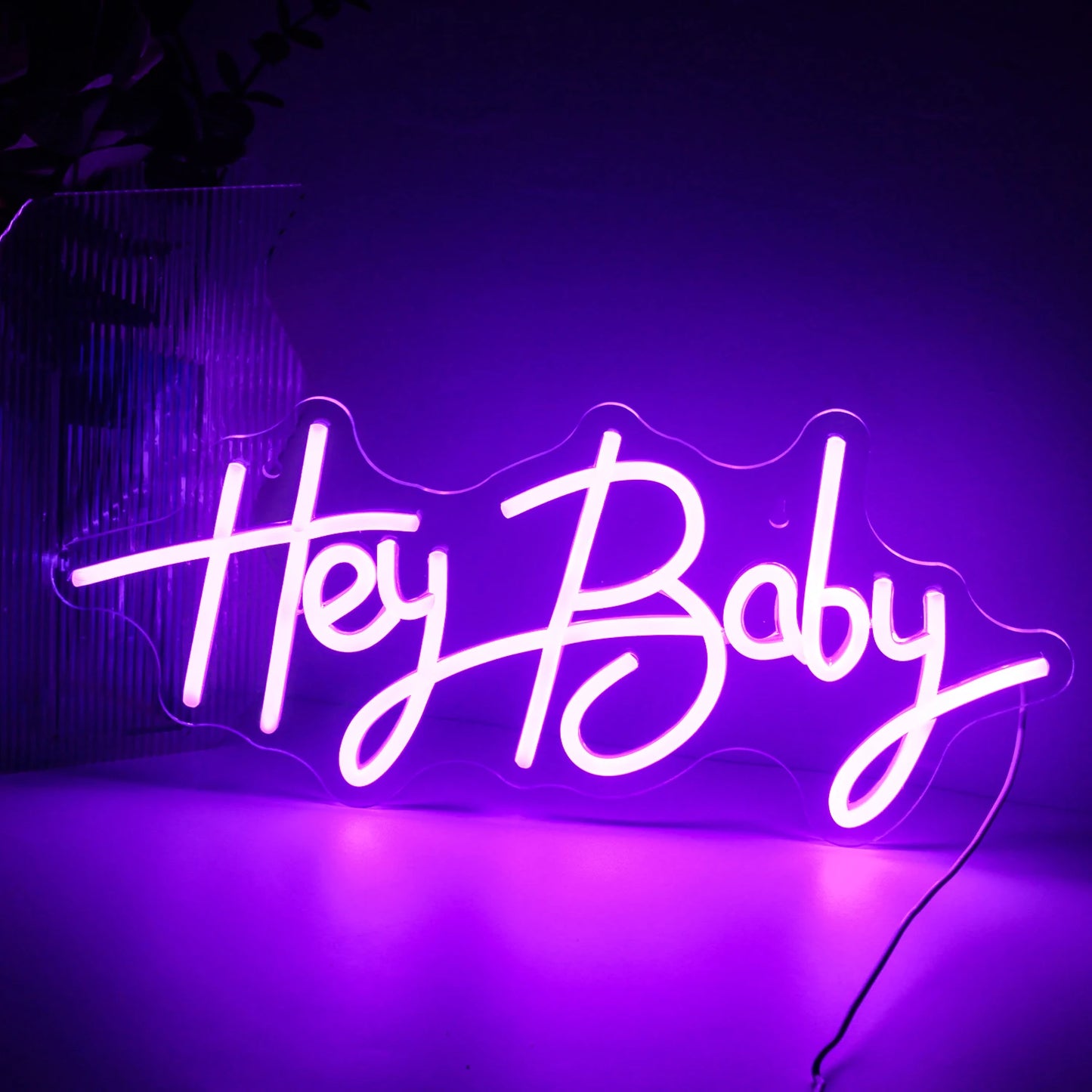 Das Bild zeigt ein lebendiges, handgefertigtes LED-Neonschild mit der Aufschrift „Hey Baby“ in einer verspielten Schreibschrift.