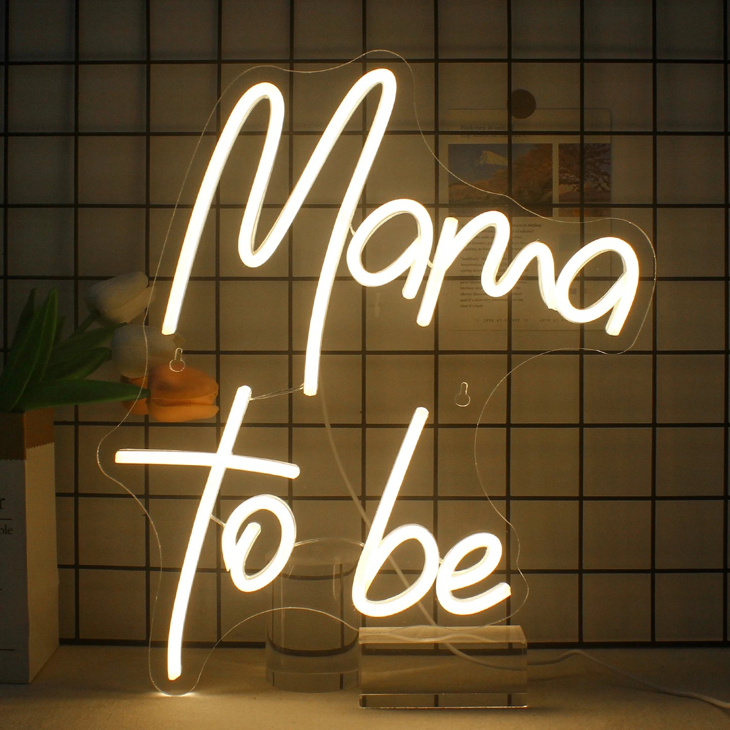 Das Bild zeigt ein lebendiges und stilvolles LED-Neonschild mit dem Satz „Mama to Be“ in eleganter Schreibschrift.