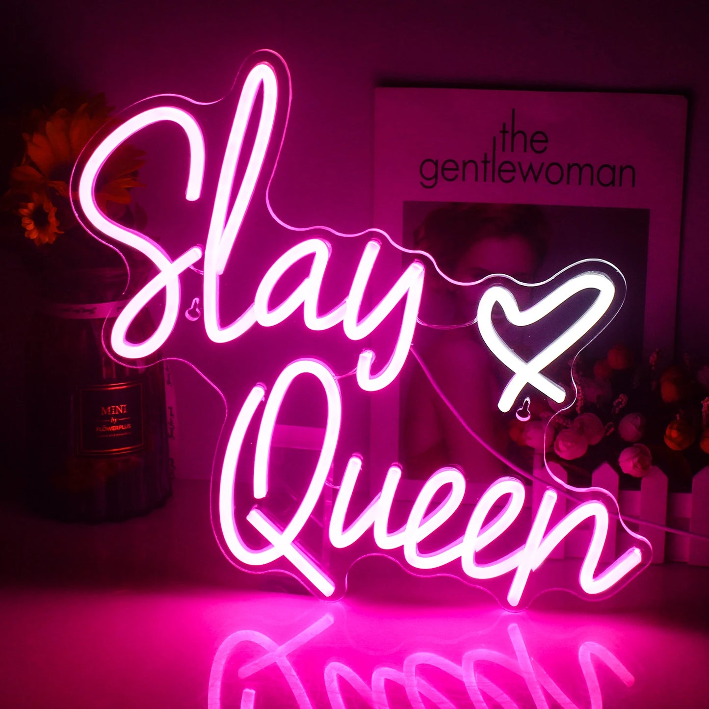 Das Bild zeigt ein leuchtendes LED-Neonschild mit den Worten „Slay Queen“ in eleganter Schreibschrift.