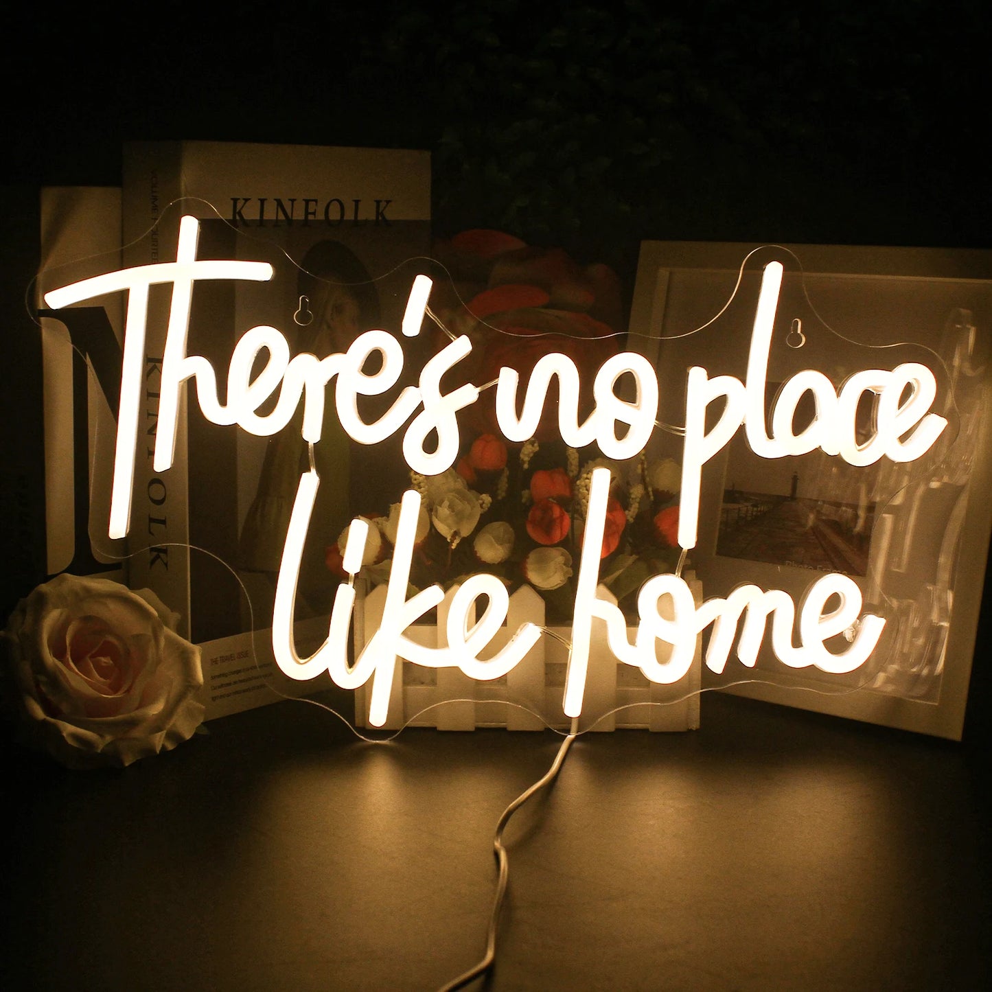 Das Bild zeigt ein stilvolles und lebendiges LED-Neonschild mit dem Satz „There’s No Place Like Home“.