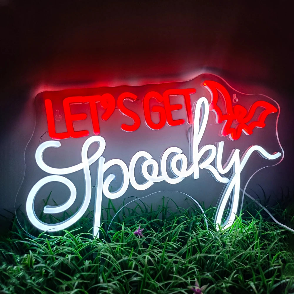 Das Bild zeigt ein leuchtendes LED-Neonschild mit den Worten „Let’s Get Spooky“ in einer fetten, ausgefallenen Schriftart.