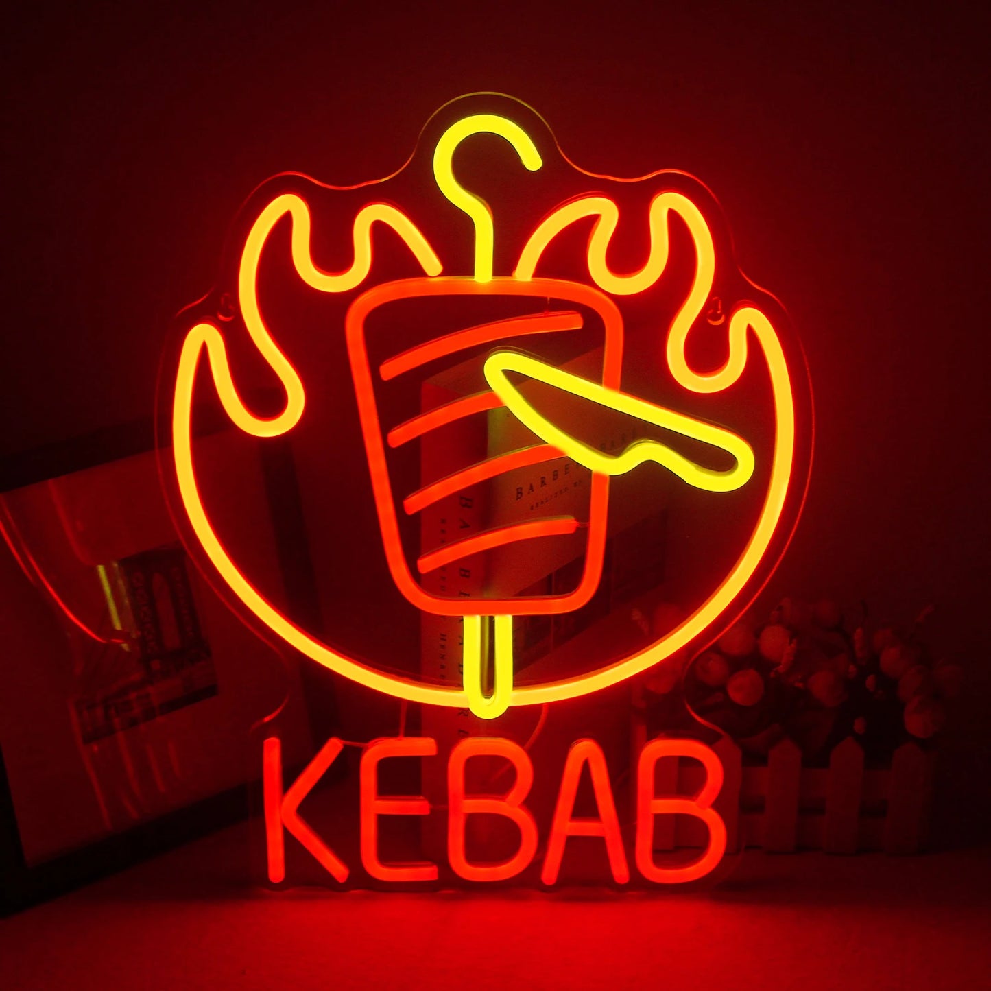 Das Bild zeigt ein leuchtendes LED-Neonschild in Form eines Kebab-Spießes.