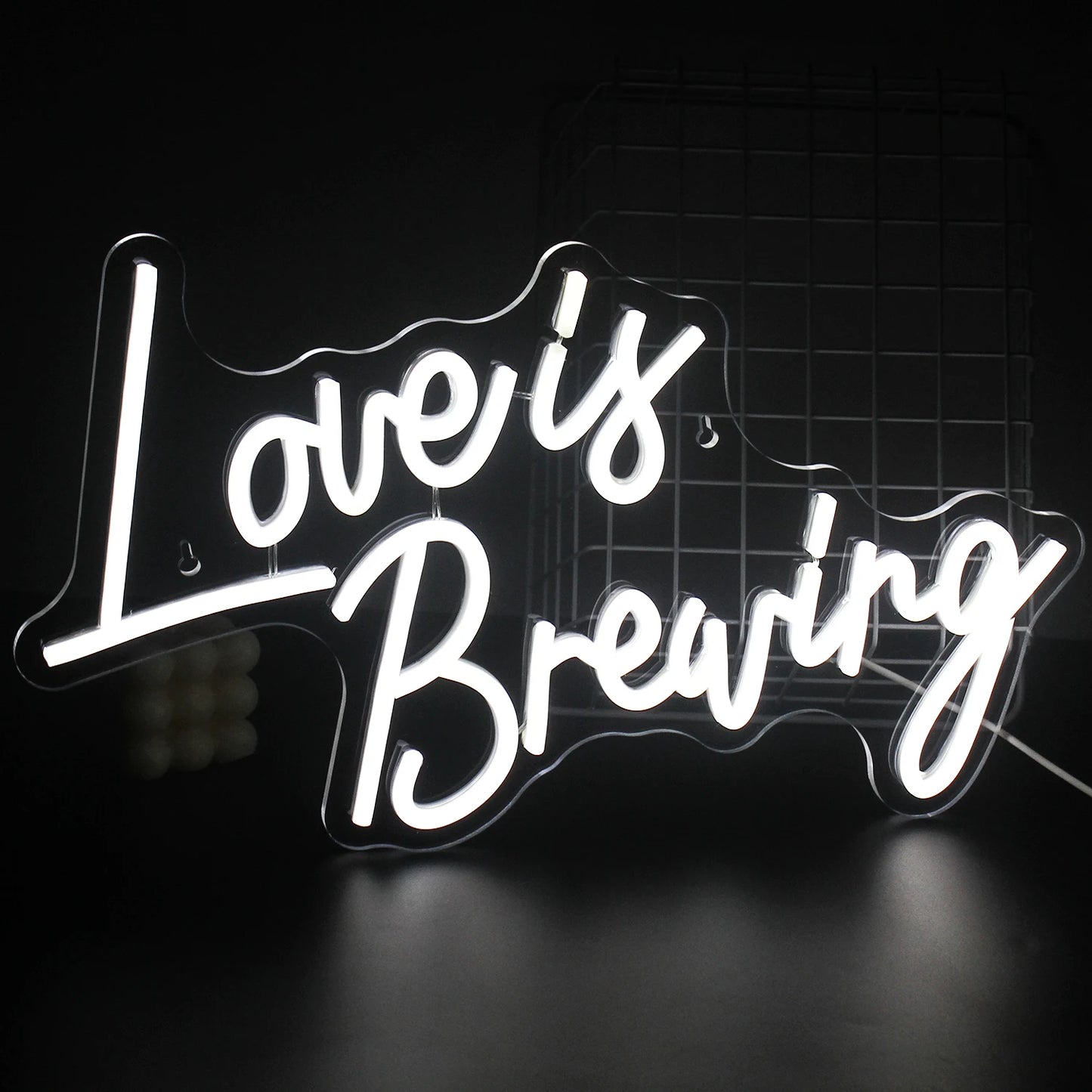 Ein leuchtendes LED-Neonschild mit dem Satz „Love is Breaking“ und kräftiger, moderner Typografie.