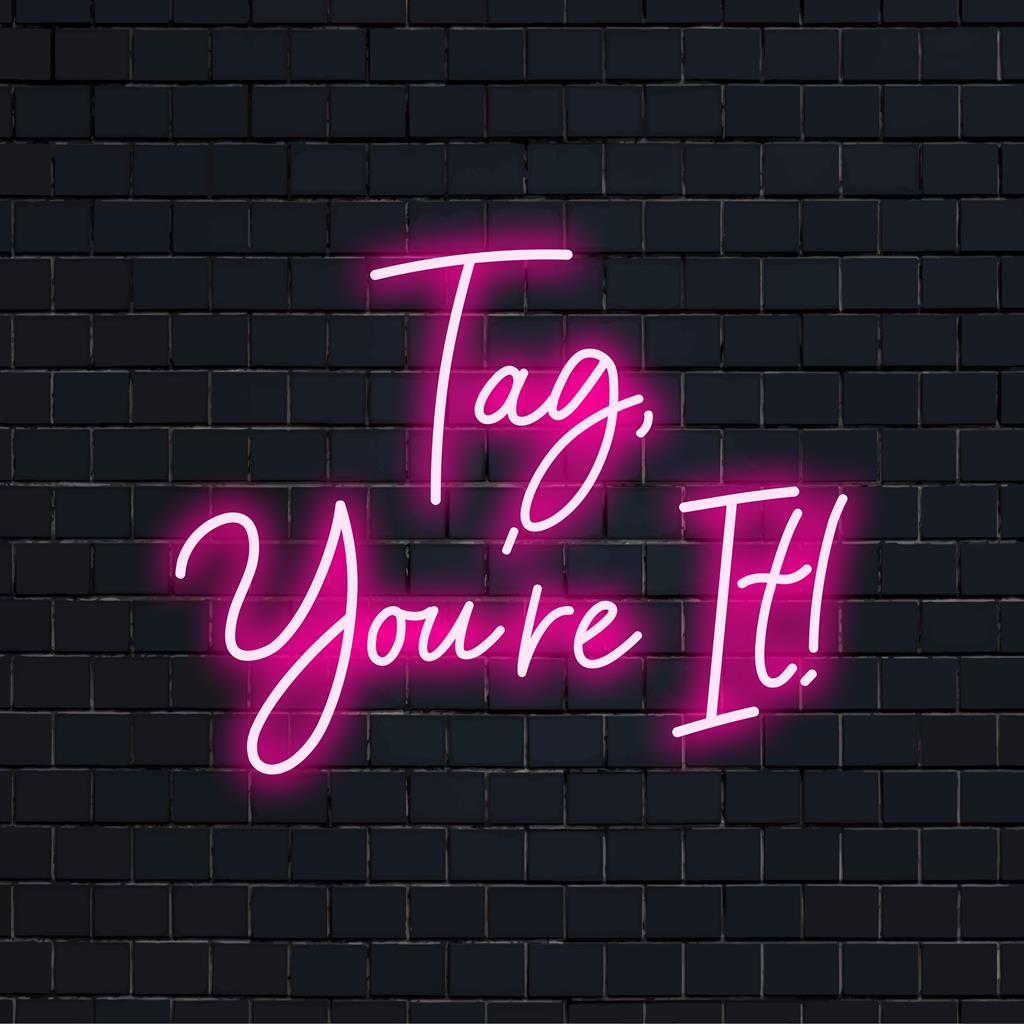 Lebendiges, individuell angefertigtes LED-Neonschild mit der verspielten Botschaft „Tag, You‘re It!“, perfekt für eine einzigartige Lichtdekoration.