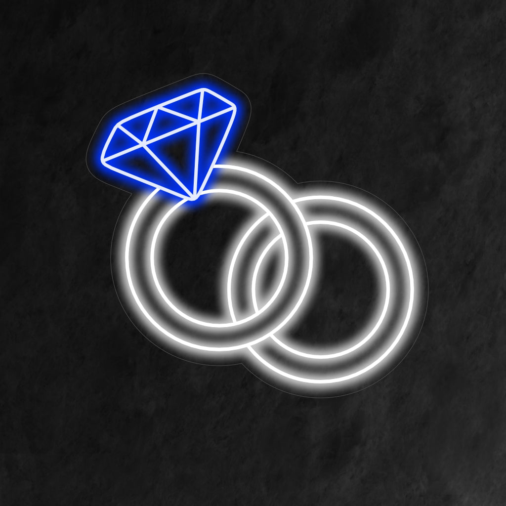„Wedding Rings Neon Sign“ symbolisiert mit sanftem Leuchten ewige Liebe und schafft eine romantische Atmosphäre, die die Vereinigung zweier Herzen feiert.