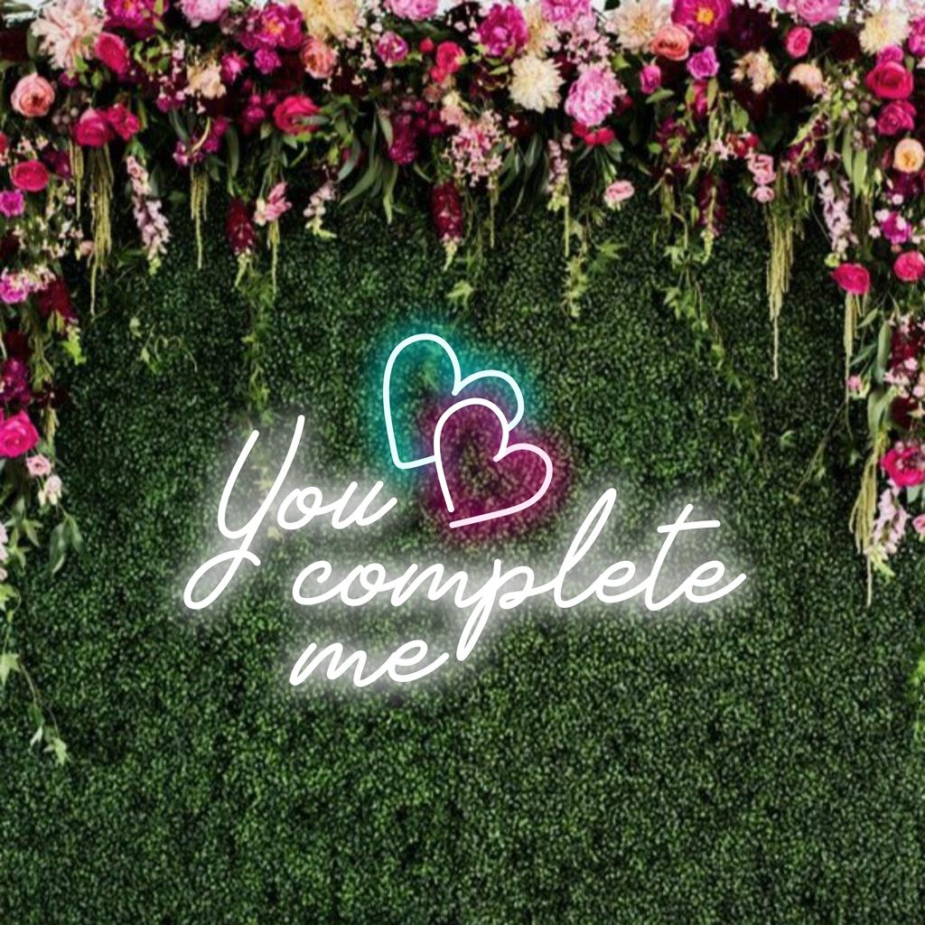 Individuelles LED-Neonschild mit den ineinander verschlungenen Worten „You Complete Me“, perfekt für eine romantische Neon-Wanddekoration.