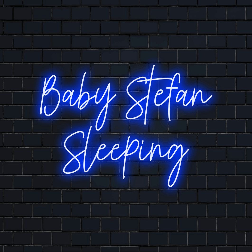 Baby Stefan Sleeping Custom Name Neon Sign, neon text light against black brick wall