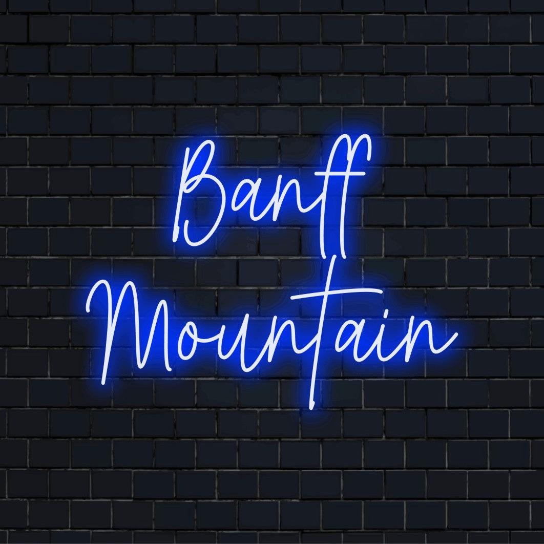 Banff Mountain Neon Light with glowing neon text on dark brick wall